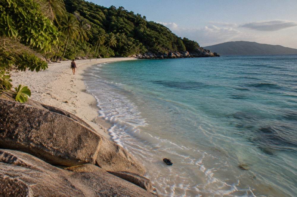Rocky headland meeting clear turquoise water at a coral beach