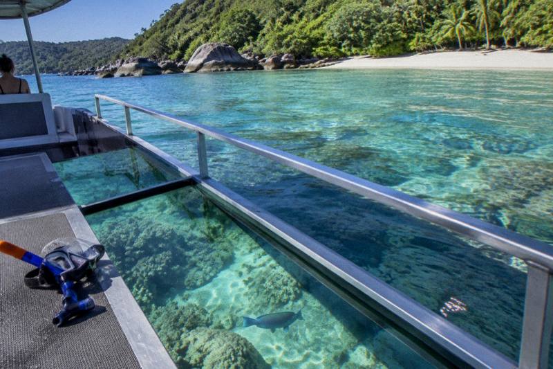A glass-bottom boat over coral in clear water off Fitzroy Island