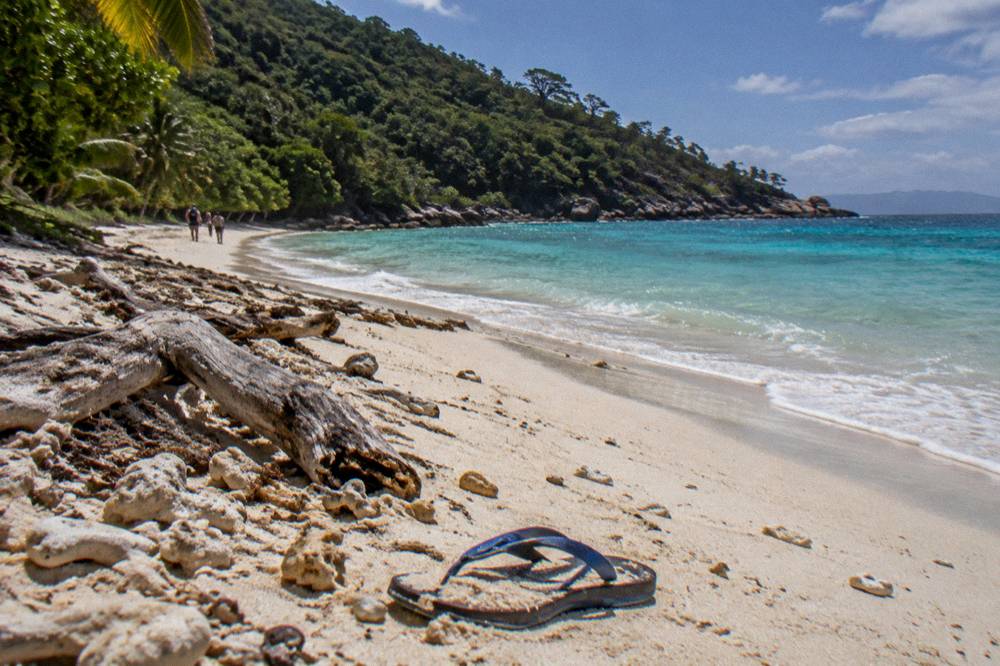 White sand beach curving along a forested island shoreline