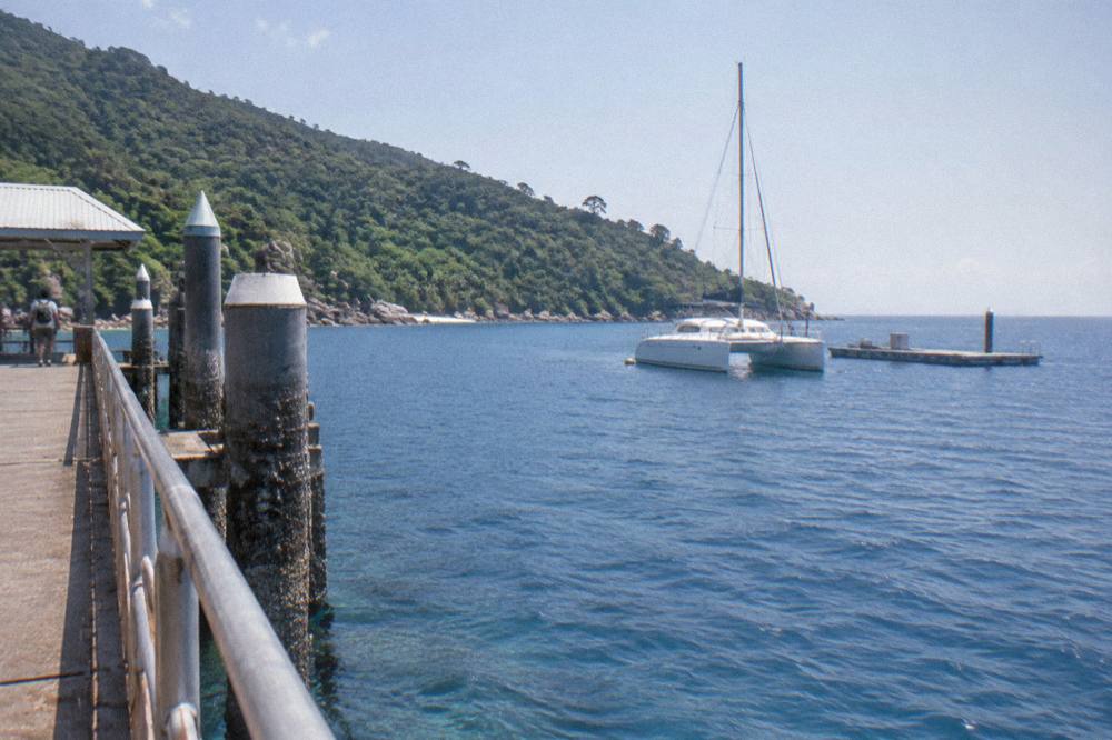Catamaran anchored beside a reef pontoon in open blue water