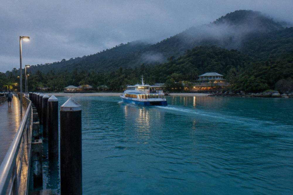 A passenger ferry approaching a jetty on a calm turquoise bay