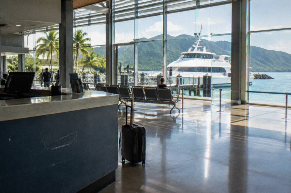 A ticket counter at a marina terminal with a ferry visible through the windows