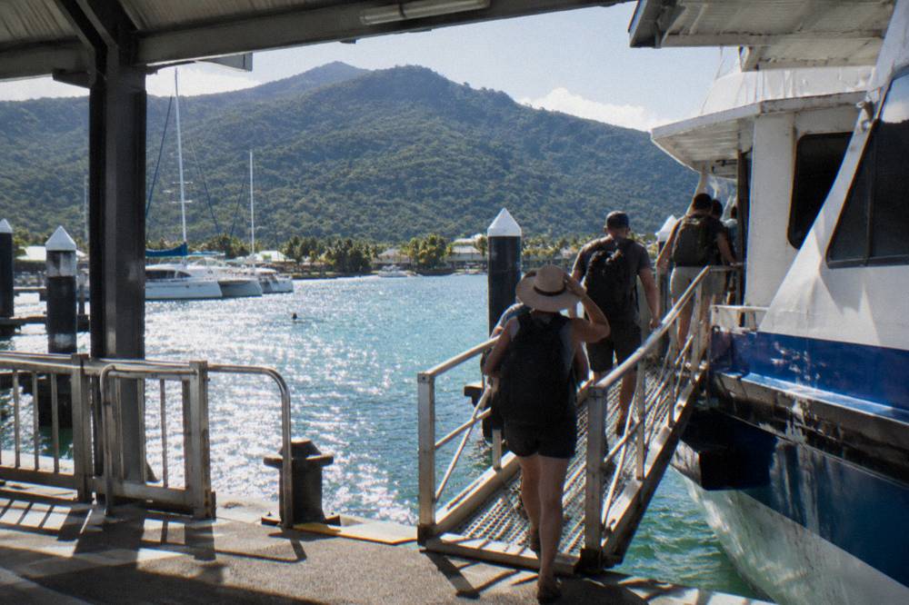 Passengers boarding a ferry at a marina berth in morning light