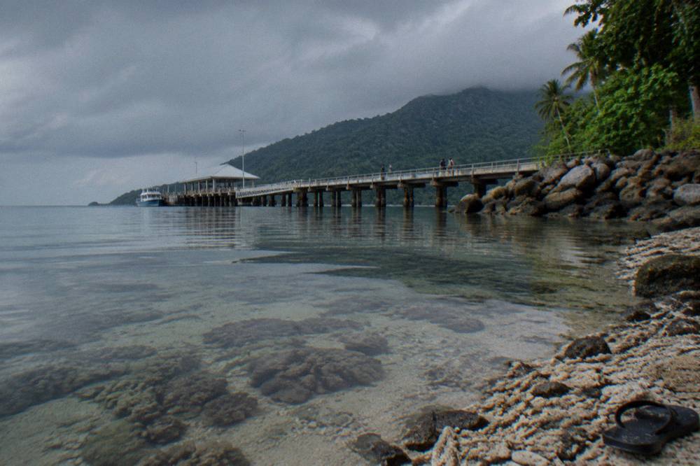 Shallow reef water near the shoreline with coral formations visible through the surface