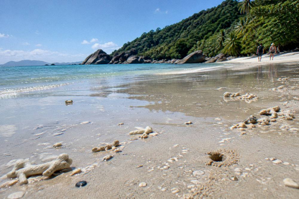Turquoise shallow water over coral beside a white coral sand beach