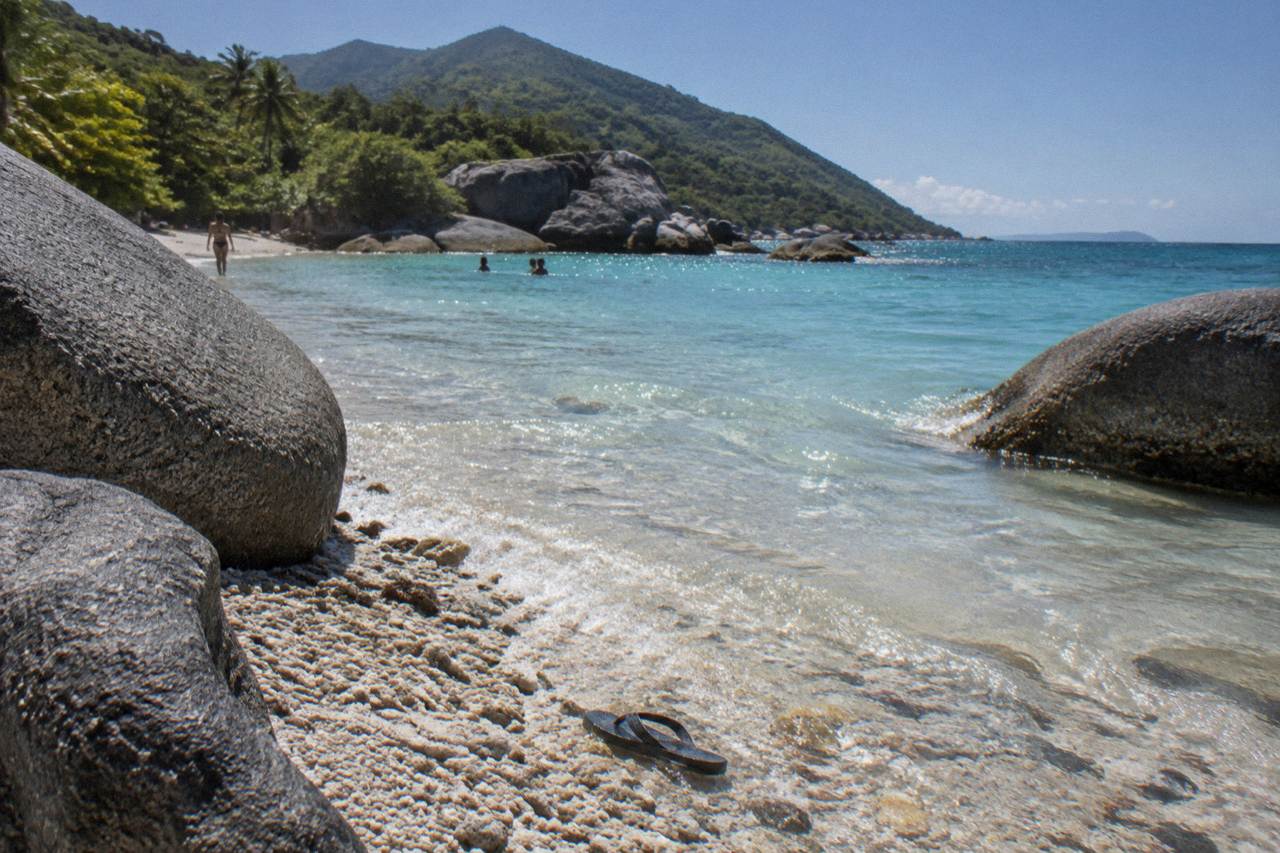 Granite boulders and turquoise water at a sheltered beach cove on a tropical island