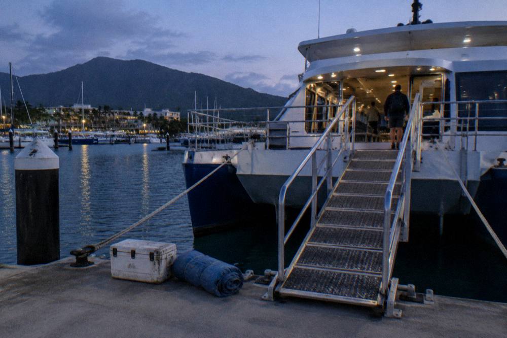 Boarding gangway at a marina jetty with a catamaran ferry waiting at the berth