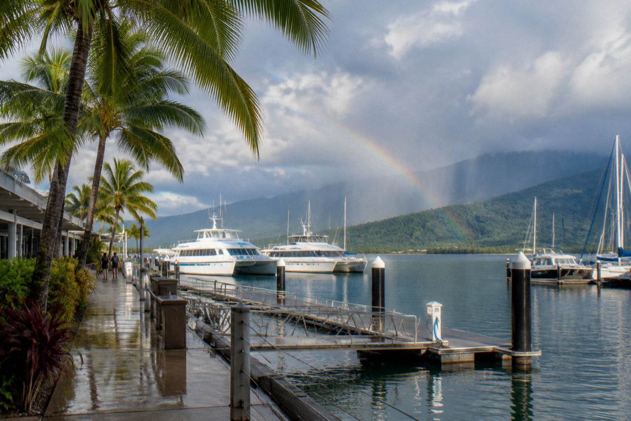 Ferry boats moored at a tropical marina in Cairns with rainforest hills behind