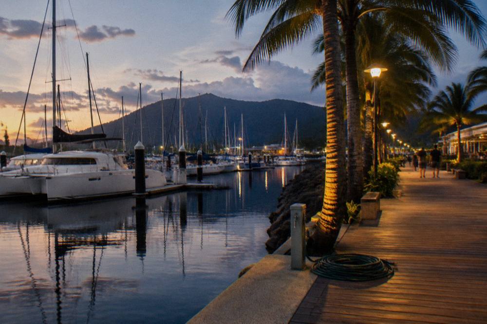 Cairns Esplanade lagoon with palm trees and a boardwalk beside calm water