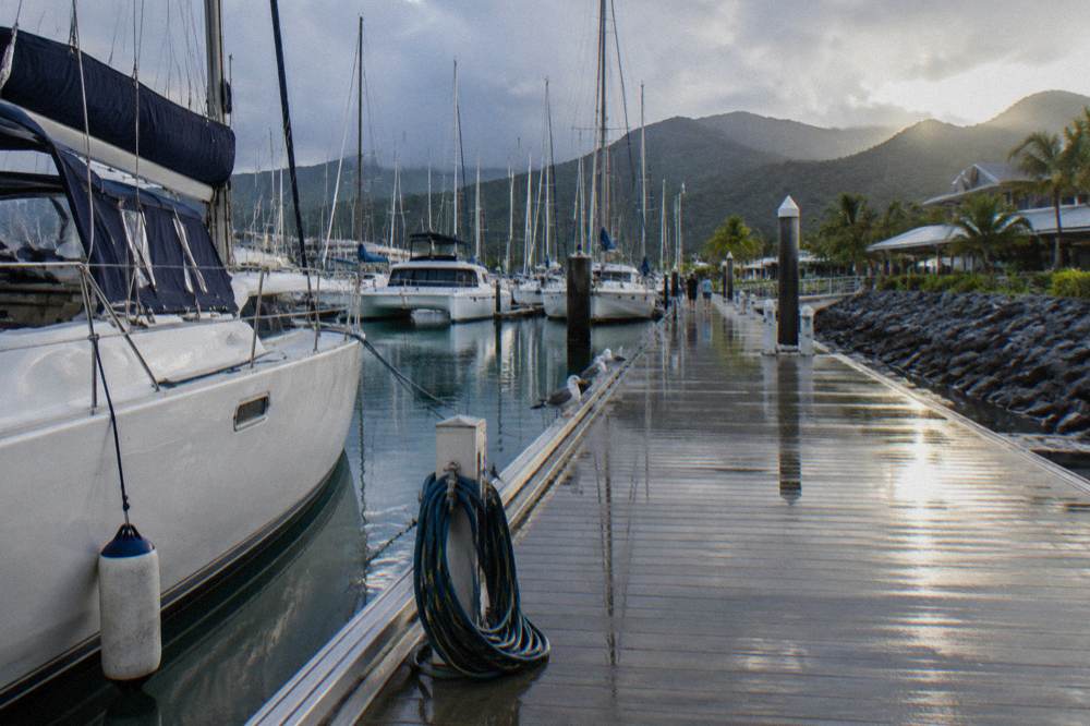 Cairns marina boardwalk with moored boats and ferry berths in morning light