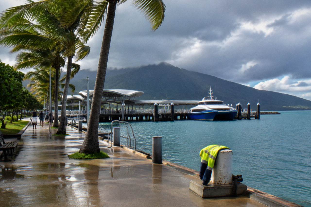 Cairns waterfront promenade at midday with palm trees and calm water